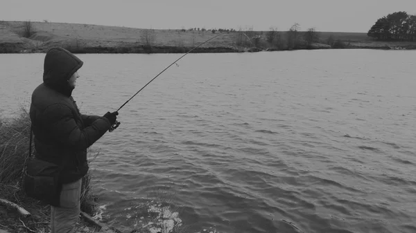 Man with spinning on the lake. Fishing — Stock Photo, Image