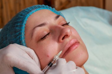 Kozmetik enjeksiyon spa salonda. Güzellik uzmanı hastanın yüz içine enjeksiyon yapar.