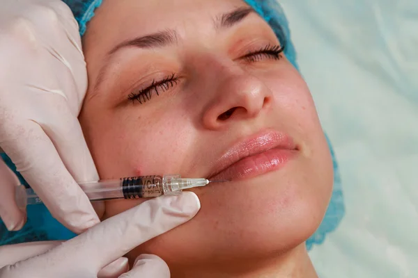 Cosmetic injection in the spa salon. Beautician makes injection into the patient's face. — Stock Photo, Image