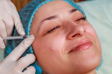 Kozmetik enjeksiyon spa salonda. Güzellik uzmanı hastanın yüz içine enjeksiyon yapar.