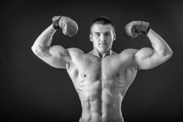 Fisiculturista posando em diferentes poses demonstrando seus músculos. Falha num fundo escuro. Homem mostrando músculos se esforçando. Bonito atleta corpo muscular . — Fotografia de Stock