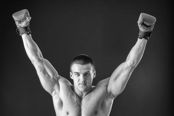 Bodybuilder poseren in verschillende poses aan te tonen hun spieren. Storing op een donkere achtergrond. Mannelijke weergegeven: spieren spannen. Mooi gespierd lichaam atleet. — Stockfoto