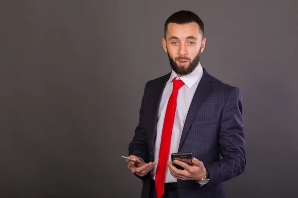 Joven hombre de negocios. Un hombre con un bonito traje, camisa blanca, corbata roja . — Foto de Stock