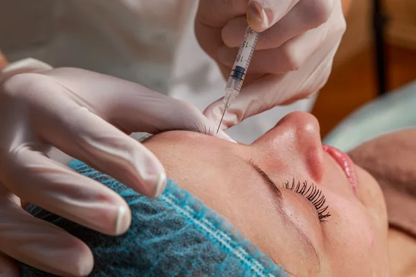 Cosmetic injection in the spa salon. Beautician makes injection into the patient's face. — Stock Photo, Image