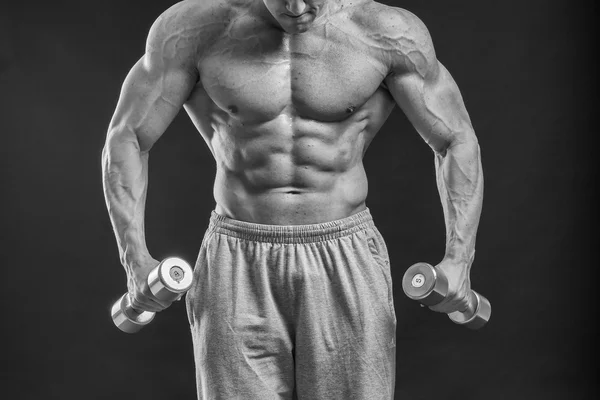 A very strong man is engaged in the gym — Stock Photo, Image