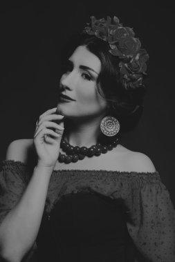 Karanlık bir arka plan üzerinde güzel, gizemli, şirin esmer. Siyah ve beyaz fotoğraf güzel gizemli esmer.