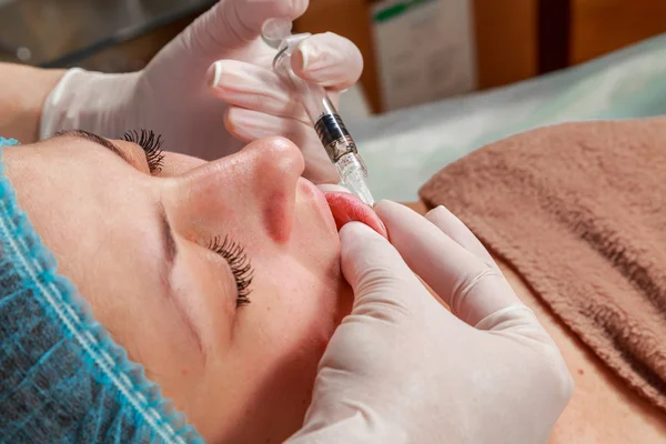 Cosmetic injection in the spa salon. Beautician makes injection into the patient's face. Beauty injections, mesotherapy, revitalization, cosmetic medicine injection - the concept of rejuvenation.