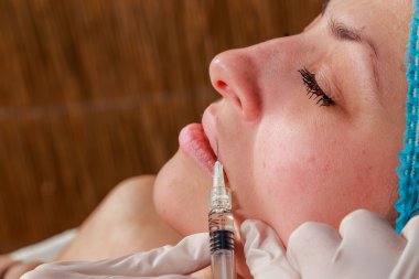 Kozmetik enjeksiyon spa salonda. Güzellik uzmanı hastanın yüz içine enjeksiyon yapar.