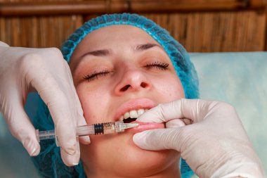 Kozmetik enjeksiyon spa salonda. Güzellik uzmanı hastanın yüz içine enjeksiyon yapar.