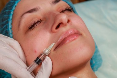 Kozmetik enjeksiyon spa salonda. Güzellik uzmanı hastanın yüz içine enjeksiyon yapar.