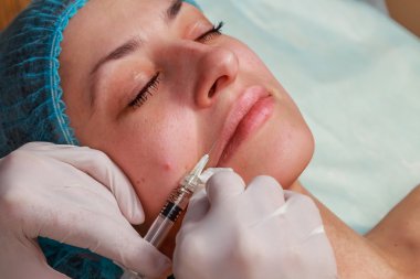 Kozmetik enjeksiyon spa salonda. Güzellik uzmanı hastanın yüz içine enjeksiyon yapar.