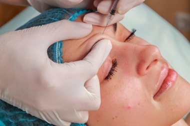 Kozmetik enjeksiyon spa salonda. Güzellik uzmanı hastanın yüz içine enjeksiyon yapar.
