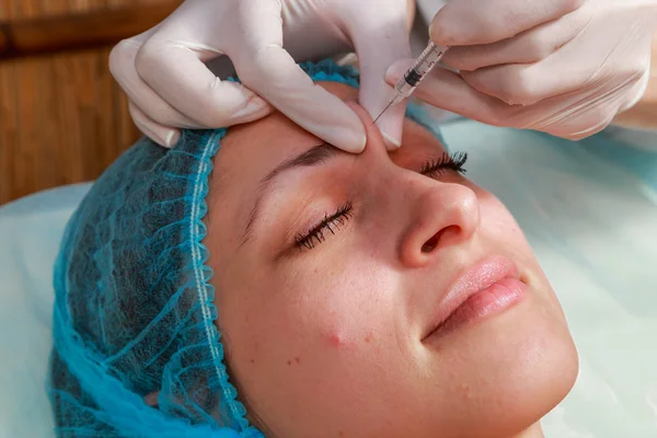 Kosmetická injekce do wellness salonu. Kosmetička je injekce do tváře pacienta. — Stock fotografie