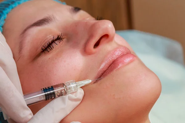 Injection cosmétique dans le spa. Esthéticienne fait l'injection dans le visage du patient . — Photo