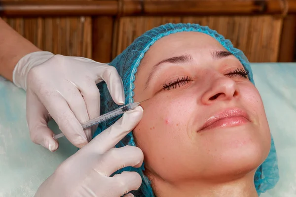 Kozmetik enjeksiyon spa salonda. Güzellik uzmanı hastanın yüz içine enjeksiyon yapar.