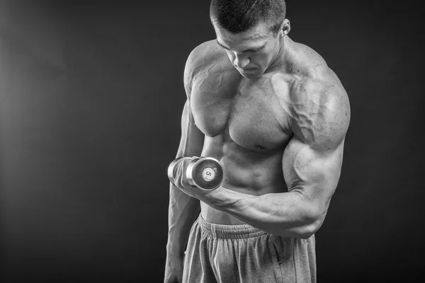 Culturista posando en diferentes poses demostrando sus músculos. Fracaso en un fondo oscuro. Varón mostrando tensión muscular. Hermoso atleta cuerpo muscular . — Foto de Stock