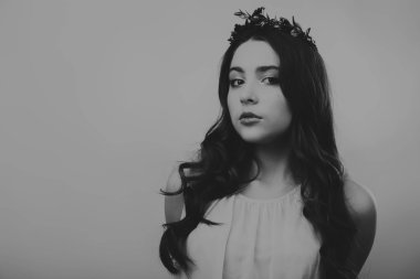 Karanlık bir arka plan üzerinde güzel, gizemli, şirin esmer. Siyah ve beyaz fotoğraf güzel gizemli esmer.