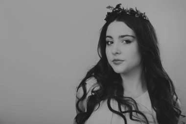 Karanlık bir arka plan üzerinde güzel, gizemli, şirin esmer. Siyah ve beyaz fotoğraf güzel gizemli esmer.