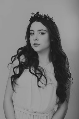 Karanlık bir arka plan üzerinde güzel, gizemli, şirin esmer. Siyah ve beyaz fotoğraf güzel gizemli esmer.