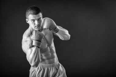 Boks eldivenleri adam. Siyah arka plan üzerinde genç boksör savaşçısı. Savaşmaya hazır boksörü. Boks, egzersiz, kas, güç, güç - eğitim ve boks gücü kavramı