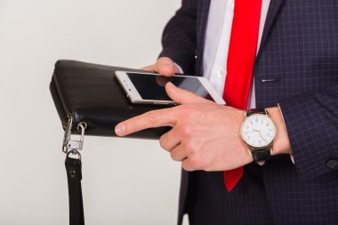 İnsan elinde telefon yakın çekim. Saygın adamın ellerini başarısında öznitelikleri. Çanta, cep telefonu ve pahalı bir saat