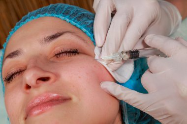 Kozmetik enjeksiyon spa salonda. Güzellik uzmanı hastanın yüz içine enjeksiyon yapar. Güzellik enjeksiyonları, Mezoterapi, yeniden canlandırılması, kozmetik tıp enjeksiyon - gençleştirme kavramı.