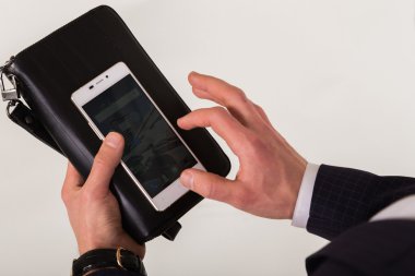 İnsan elinde telefon yakın çekim. Saygın adamın ellerini başarısında öznitelikleri. Çanta, cep telefonu ve pahalı bir saat