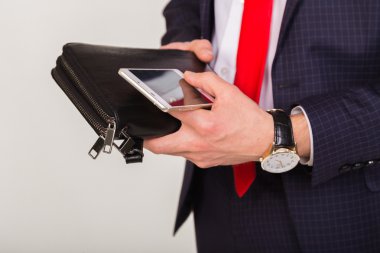 İnsan elinde telefon yakın çekim. Saygın adamın ellerini başarısında öznitelikleri. Çanta, cep telefonu ve pahalı bir saat