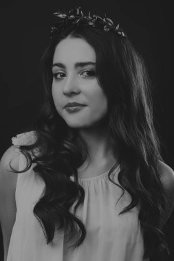 Karanlık bir arka plan üzerinde güzel, gizemli, şirin esmer. Siyah ve beyaz fotoğraf güzel gizemli esmer.