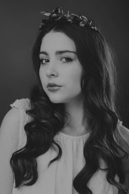 Karanlık bir arka plan üzerinde güzel, gizemli, şirin esmer. Siyah ve beyaz fotoğraf güzel gizemli esmer.