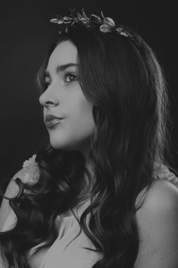 Karanlık bir arka plan üzerinde güzel, gizemli, şirin esmer. Siyah ve beyaz fotoğraf güzel gizemli esmer.