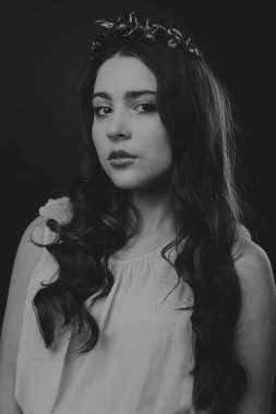 Karanlık bir arka plan üzerinde güzel, gizemli, şirin esmer. Siyah ve beyaz fotoğraf güzel gizemli esmer.