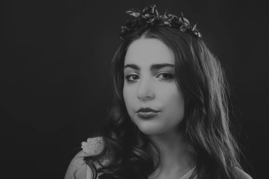 Karanlık bir arka plan üzerinde güzel, gizemli, şirin esmer. Siyah ve beyaz fotoğraf güzel gizemli esmer.