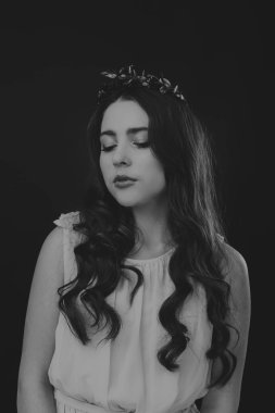 Karanlık bir arka plan üzerinde güzel, gizemli, şirin esmer. Siyah ve beyaz fotoğraf güzel gizemli esmer.