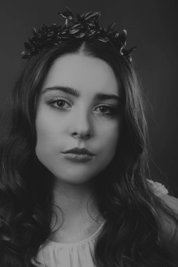 Karanlık bir arka plan üzerinde güzel, gizemli, şirin esmer. Siyah ve beyaz fotoğraf güzel gizemli esmer.