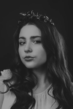 Karanlık bir arka plan üzerinde güzel, gizemli, şirin esmer. Siyah ve beyaz fotoğraf güzel gizemli esmer.