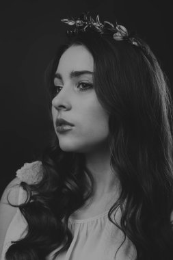 Karanlık bir arka plan üzerinde güzel, gizemli, şirin esmer. Siyah ve beyaz fotoğraf güzel gizemli esmer.