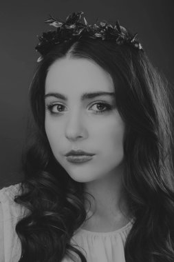 Karanlık bir arka plan üzerinde güzel, gizemli, şirin esmer. Siyah ve beyaz fotoğraf güzel gizemli esmer.