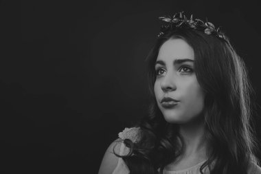 Karanlık bir arka plan üzerinde güzel, gizemli, şirin esmer. Siyah ve beyaz fotoğraf güzel gizemli esmer.