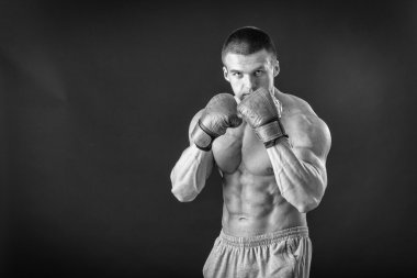 Boks eldivenleri adam. Siyah arka plan üzerinde genç boksör savaşçısı. Savaşmaya hazır boksörü. Boks, egzersiz, kas, güç, güç - eğitim ve boks gücü kavramı