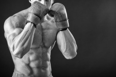 Boks eldivenleri adam. Siyah arka plan üzerinde genç boksör savaşçısı. Savaşmaya hazır boksörü. Boks, egzersiz, kas, güç, güç - eğitim ve boks gücü kavramı
