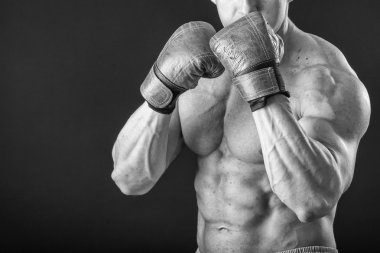 Boks eldivenleri adam. Siyah arka plan üzerinde genç boksör savaşçısı. Savaşmaya hazır boksörü. Boks, egzersiz, kas, güç, güç - eğitim ve boks gücü kavramı