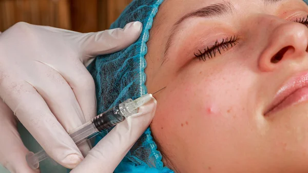 Kosmetiska injektion i spasalong. Kosmetolog gör injektion i patientens ansikte. — Stockfoto