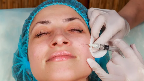 Cosmetic injection in the spa salon. Beautician makes injection into the patient's face. — Stock Photo, Image