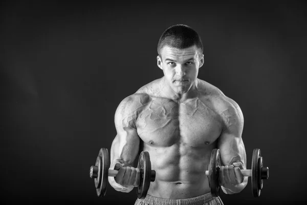 Bodybuilder posing in different poses demonstrating their muscles. Failure on a dark background. Male showing muscles straining. Beautiful muscular body athlete. — Stock Photo, Image