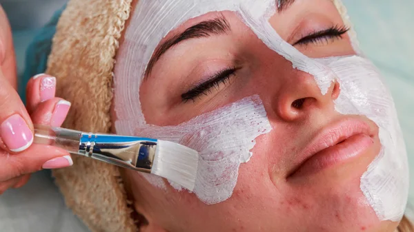 Menina com um esteticista no salão de spa. Esteticista realiza procedimentos cosméticos. Aplicação de creme cosmético. Cosmetologia, facial, beleza - O conceito de cuidados com a pele facial. Artigo sobre cosmetologia . — Fotografia de Stock