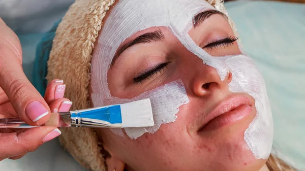 Chica con una esteticista en el salón de spa. esteticista realiza procedimientos cosméticos. Aplicación de crema cosmética. Cosmetología, facial, belleza - El concepto de cuidado de la piel facial. Artículo sobre cosmetología . —  Fotos de Stock