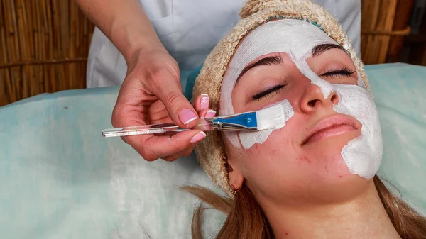 Ragazza con un estetista al centro benessere. Estetista esegue procedure cosmetiche.applicazione di crema cosmetica. Cosmetologia, viso, bellezza - Il concetto di cura della pelle del viso. Articolo sulla cosmetologia . — Foto Stock