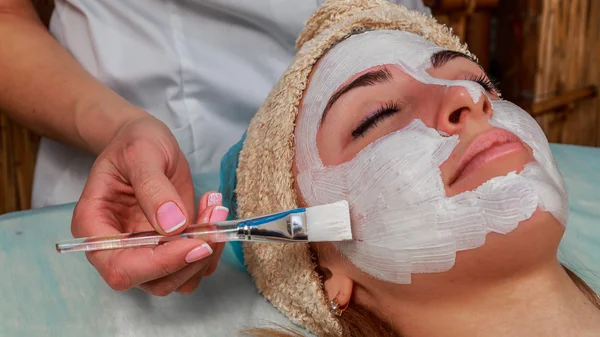 Ragazza con un estetista al centro benessere. Estetista esegue procedure cosmetiche.applicazione di crema cosmetica. Cosmetologia, viso, bellezza - Il concetto di cura della pelle del viso. Articolo sulla cosmetologia . — Foto Stock