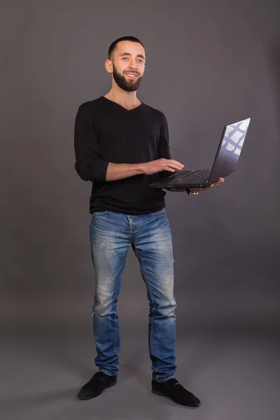 Elegante y exitoso hombre de negocios con una computadora portátil — Foto de Stock